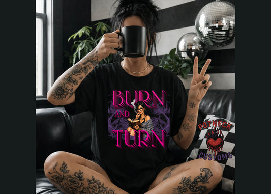 Person wearing a black t-shirt with 'Burn and Turn' design, holding a mug in a room with disco balls and plants.