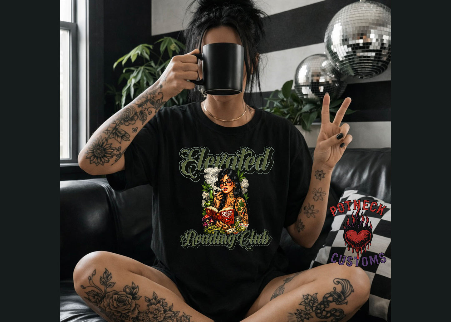 Person wearing a black t-shirt with a graphic design, sitting in a room with disco balls and plants.